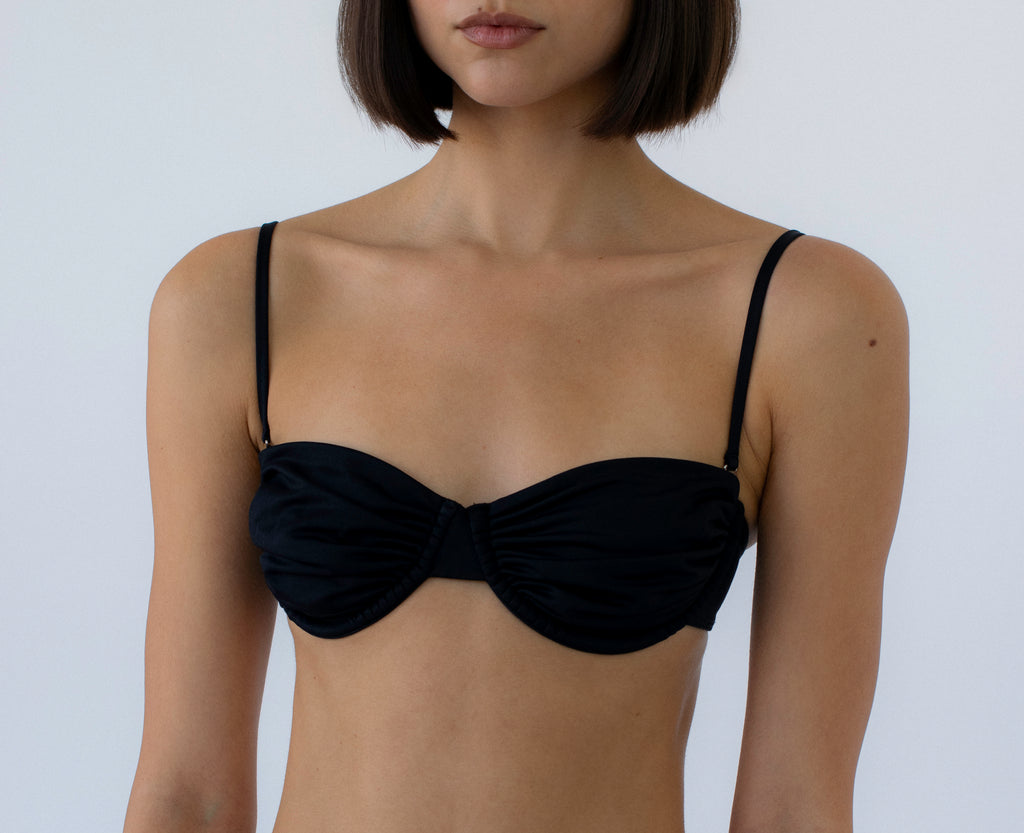 black ruched balconette bikini top on a person against a white background